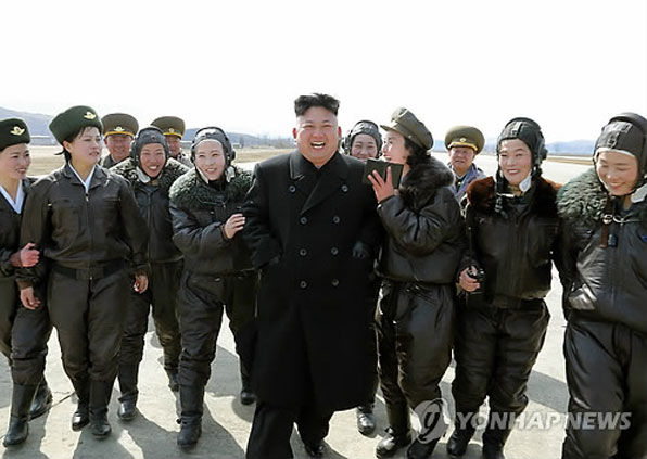 김정은 노동당 위원장이 북한군 항공 및 반항공군 제2620군부대를 방문해 비행훈련을 지도했다. 여군 조종사들과 김정은이 활짝 웃고 있다. 아이돌 스타에 열광하는 이른바 ‘오빠부대’를 연상케 한다. (2014년 3월)