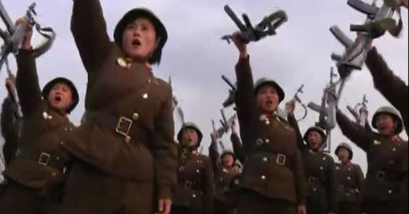 여군들이 ‘AK-47 자동소총’을 손으로 치켜 올리며 함성을 지르고 있다. 북한에서는 '아카보총'이라고 부른다고 한다. 이 소총은 사격할 때 반동이 다소 크지만 구조가 단순해 분해와 조립이 쉽고 사용하기 편하다고 한다. 